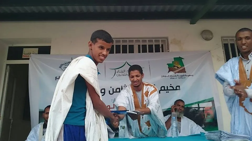 رئيس المخيم وهو يسلم جائزة لأحد المتميزين المشاركين في مخيم البناء 38